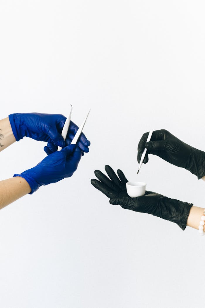 our-story Close-up of gloved hands using beauty tools, focusing on careful application.
