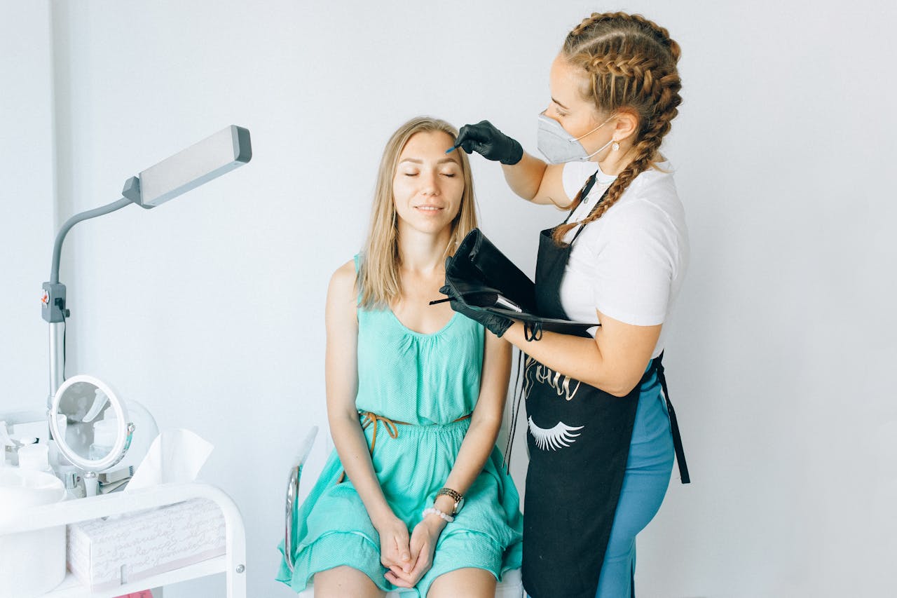 about-us A beautician performs eyebrow microblading on a woman in a modern salon setting.
